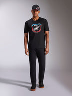 Alpinestars Plate CSF Tee, T-shirt met korte mouwen, zwart, MX-plaat graphic aan de voorkant met wit Astars-logo en blauwe en rode accenten, gedragen door model met bijpassende zwarte pet en broek, casual motorsport sportkleding