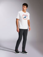 Alpinestars Plate CSF Tee, T-shirt met korte mouwen, wit, voorzien van een Astars MX plaatgrafiek aan de voorzijde in blauw en oranje, casual op motorsport geïnspireerde streetwear gedragen met een donkere broek en hoge sneakers