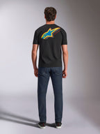 Alpinestars Angler CSF Tee, T-shirt met korte mouwen, zwart, achteraanzicht van model met groot levendig meerkleurig Astars-sterlogo en 'RACING AHEAD' tekst op de rug, gecombineerd met donkerblauwe jeans, casual motorsport streetwear