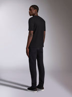 Alpinestars Authority CSF Tee, T-shirt met korte mouwen, zwart, achteraanzicht gedragen door model, casual motorsport-geïnspireerde streetwear, gecombineerd met een zwarte broek