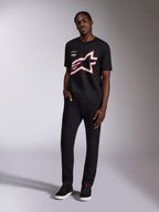 Alpinestars Authority CSF Tee, zwart T-shirt met korte mouwen, groot bijgesneden Astars-logo met rode en witte omtrek, gedragen door een model, casual motorsport streetwear