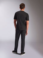 Alpinestars Trifecta CSF Tee, T-shirt met korte mouwen, zwart, achteraanzicht op mannelijk model, gedragen met zwarte broek en zwarte sneakers, casual op de motorsport geïnspireerde streetwear