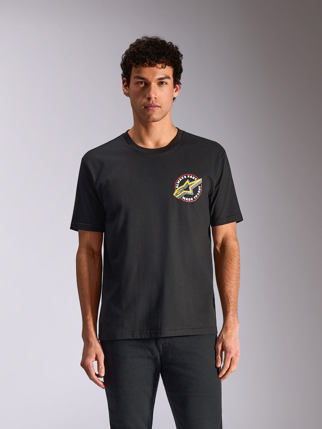 Alpinestars Aorbit CSF Tee, T-shirt met korte mouwen, zwart, ronde grafische print op de borst met Astars-logo en 'Always Fast Made to Last'-tekst, casual streetwear geïnspireerd op de motorsport