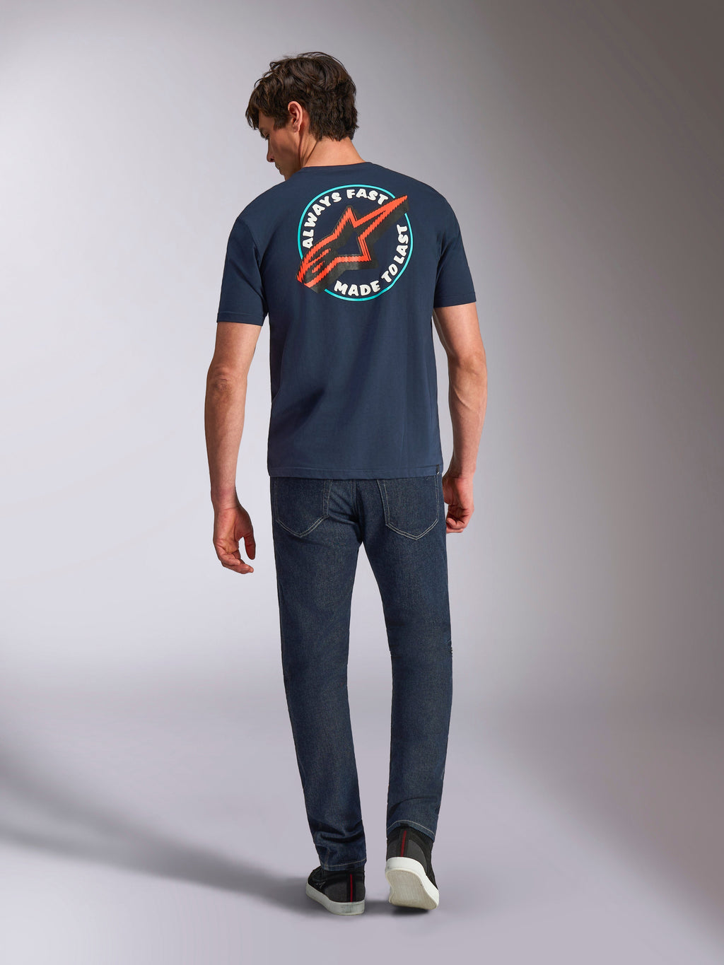 Alpinestars Aorbit CSF Tee, T-shirt met korte mouwen, navy, achteraanzicht op model met een grote ronde graphic met rood Astars-logo en 'Always Fast Made to Last'-tekst, casual motorsport streetwear