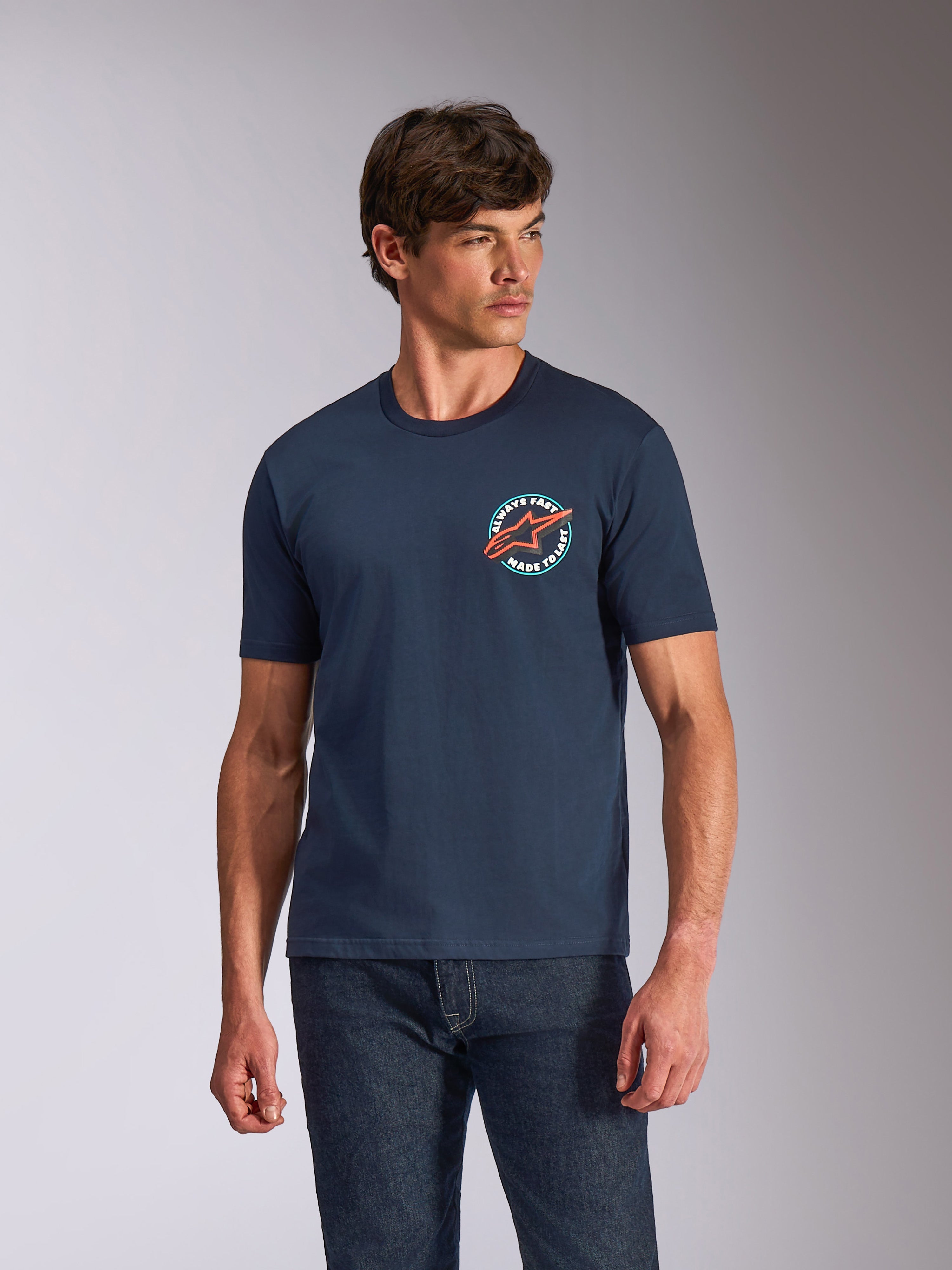 Alpinestars Aorbit CSF Tee, T-shirt met korte mouwen, navy blauw, ronde grafische print op de borst met oranje Astars-logo en 'Always Fast Made to Last' tekst, casual motorsport streetwear