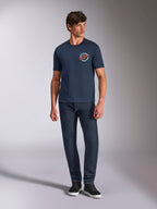 Alpinestars Aorbit CSF Tee, T-shirt met korte mouwen, donkerblauw, ronde borstgraphic met 'Always Fast Made to Last'-tekst, gedragen met donkere jeans en sneakers, casual motorsport lifestyle-kleding