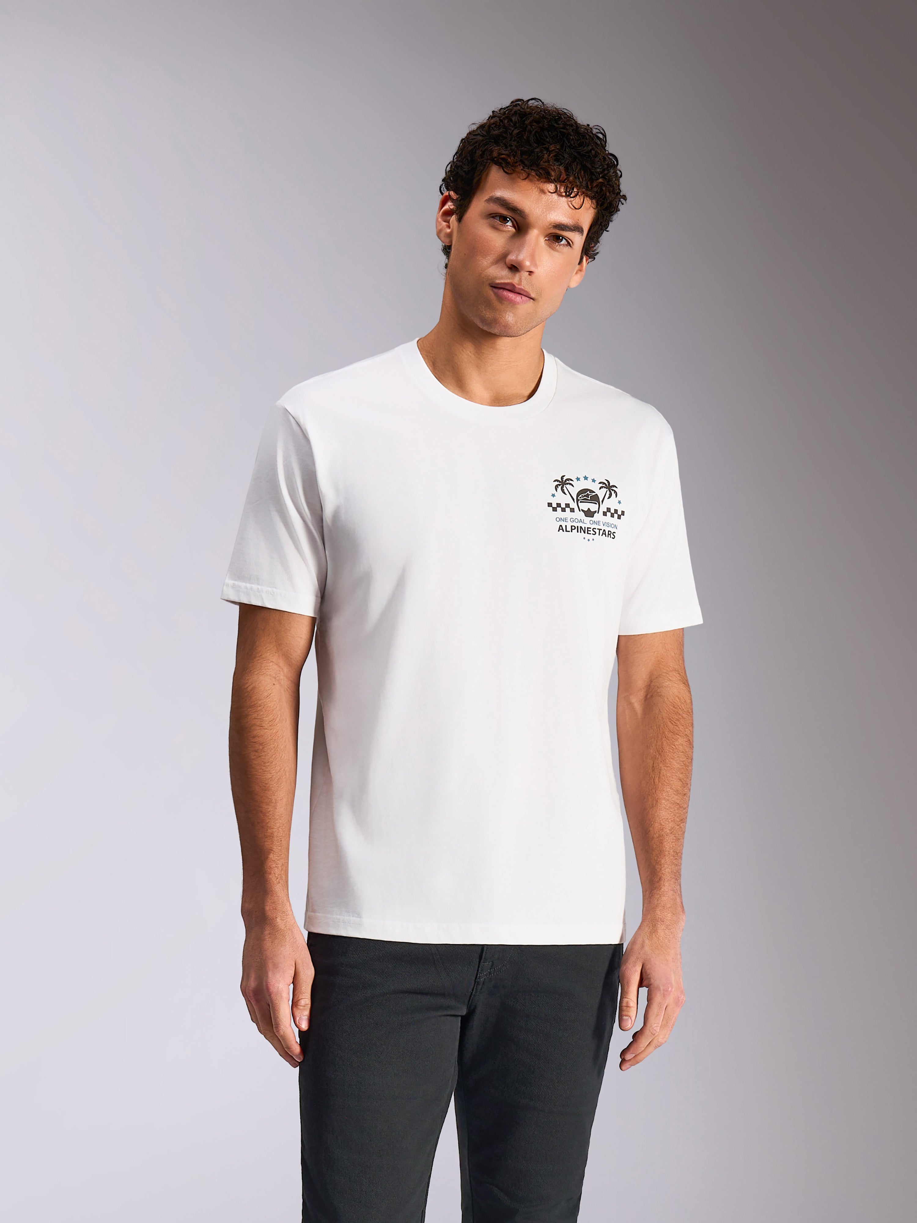 Alpinestars Order CSF Tee, T-shirt met korte mouwen, wit, borstprint met helm en palmbomen, gedragen door model met donkere broek, casual motorsport-geïnspireerde streetwear
