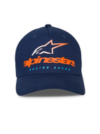 Alpinestars Instinct pet, donkerblauwe baseballpet, gebogen klep met gestructureerde kroon, oranje Alpinestars-woordmerk en gestreept sterlogo op de voorzijde, lichtblauwe "RACING AHEAD" tekst, casual sportkleding