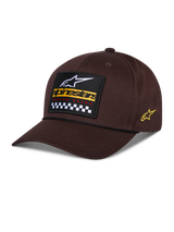 Alpinestars Matrix Snapback pet, bruin, met een geborduurde patch op de voorzijde met wit logo, geel merklogo en geblokt patroon, Astars-logo aan de zijkant, gebogen klep, casual sportkleding