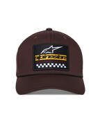 Alpinestars Matrix Snapback pet, bruin, vooraanzicht met gestructureerde kroon en gebogen klep, meerkleurige geborduurde patch met Alpinestars-branding en geblokt racemotief, zwart koorddetail, casual motorsport-stijl