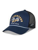 Alpinestars Finisher Trucker pet, marineblauw en zwart, gebogen klep met wit koorddetail, Alpinestars grafische print met geblokte vlaggen, gouden logo en 'Racing Ahead' tekst op de voorkant, Astars logo-borduurwerk aan de zijkant, casual motorsport-hoofdbedekking
