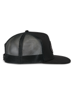 Alpinestars Contender Trucker pet, zwarte truckerpet, zijaanzicht, voorzien van een platte klep en ademende mesh achterpanelen, snapback-sluiting, casual motorsportstijl