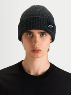 Alpinestars Bonnet Unload Rib Cuff, bonnet sportswear en maille côtelée gris chiné, porté par un modèle, avec un écusson tissé SAstars