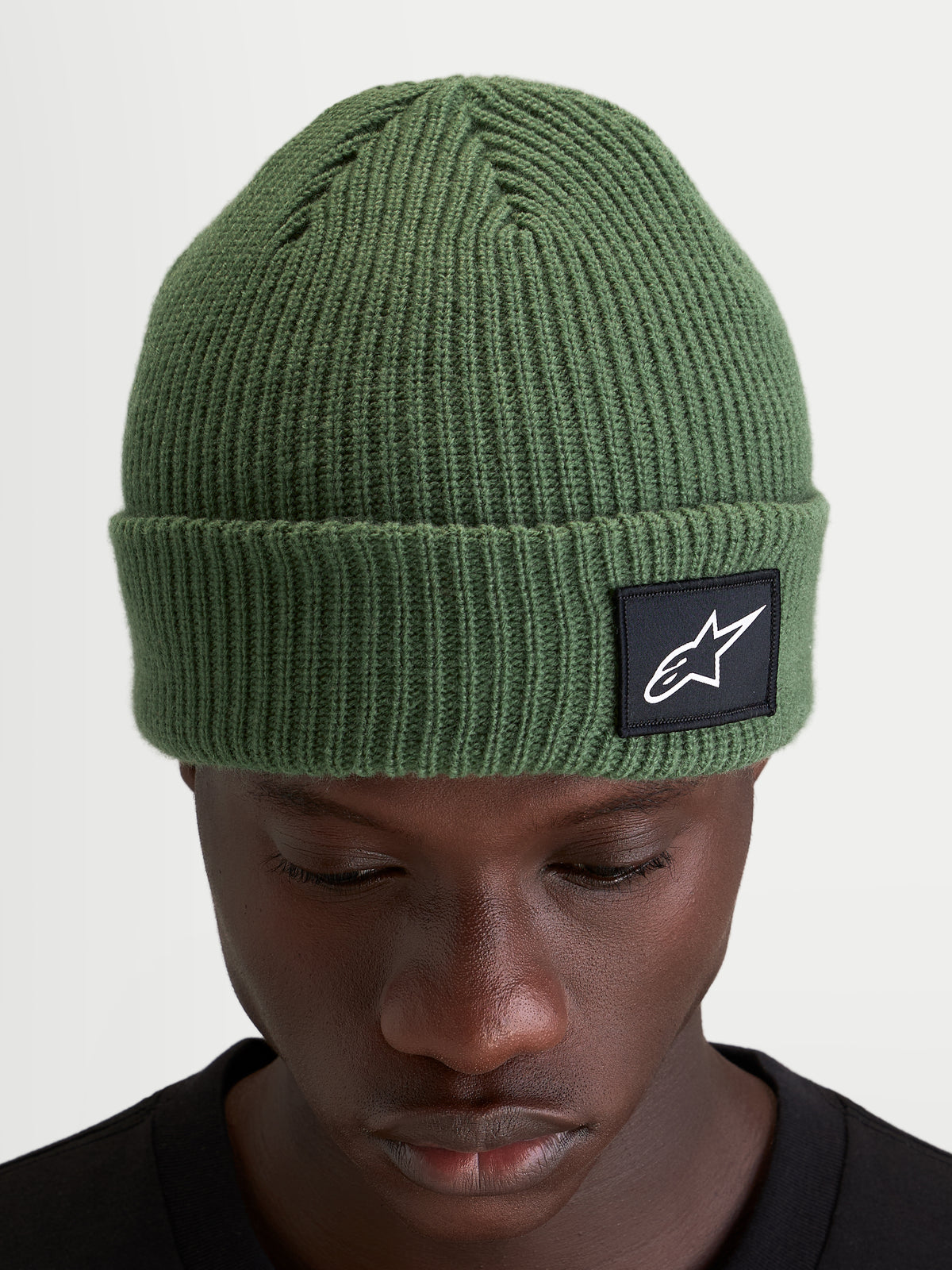 Alpinestars Unload Rib Cuff Beanie, winter sportswear knit hat, pea green, featuring a ribbed design and woven Alpinestars patch on the cuff worn by a model