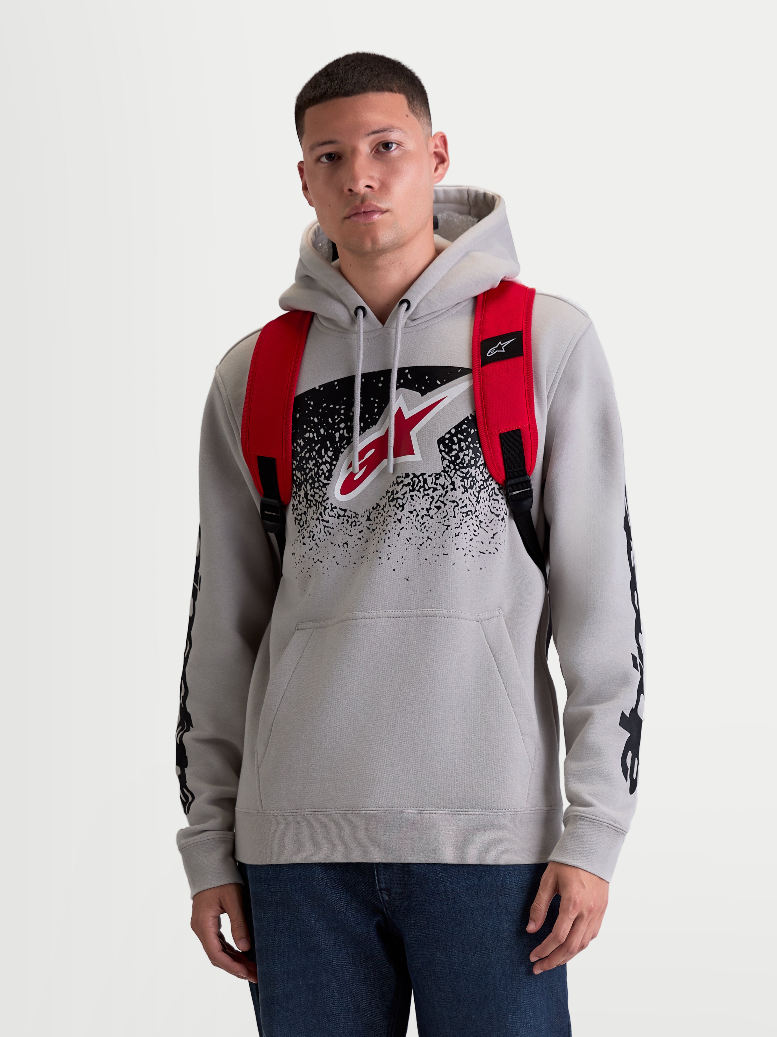 Alpinestars GFX Boss rugzak, 20L urban sportswear dagrugzak voor heren en dames, rood en zwart, duurzaam 600D polyester, vooraanzicht op model met verstelbare air-mesh schouderbanden en verhoogde siliconen branding.
