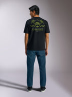 Alpinestars Order CSF Tee, t-shirt à manches courtes, noir, vue de dos présentant un motif de casque vert olive et de palmiers avec le texte « One Goal One Vision », vêtement streetwear décontracté