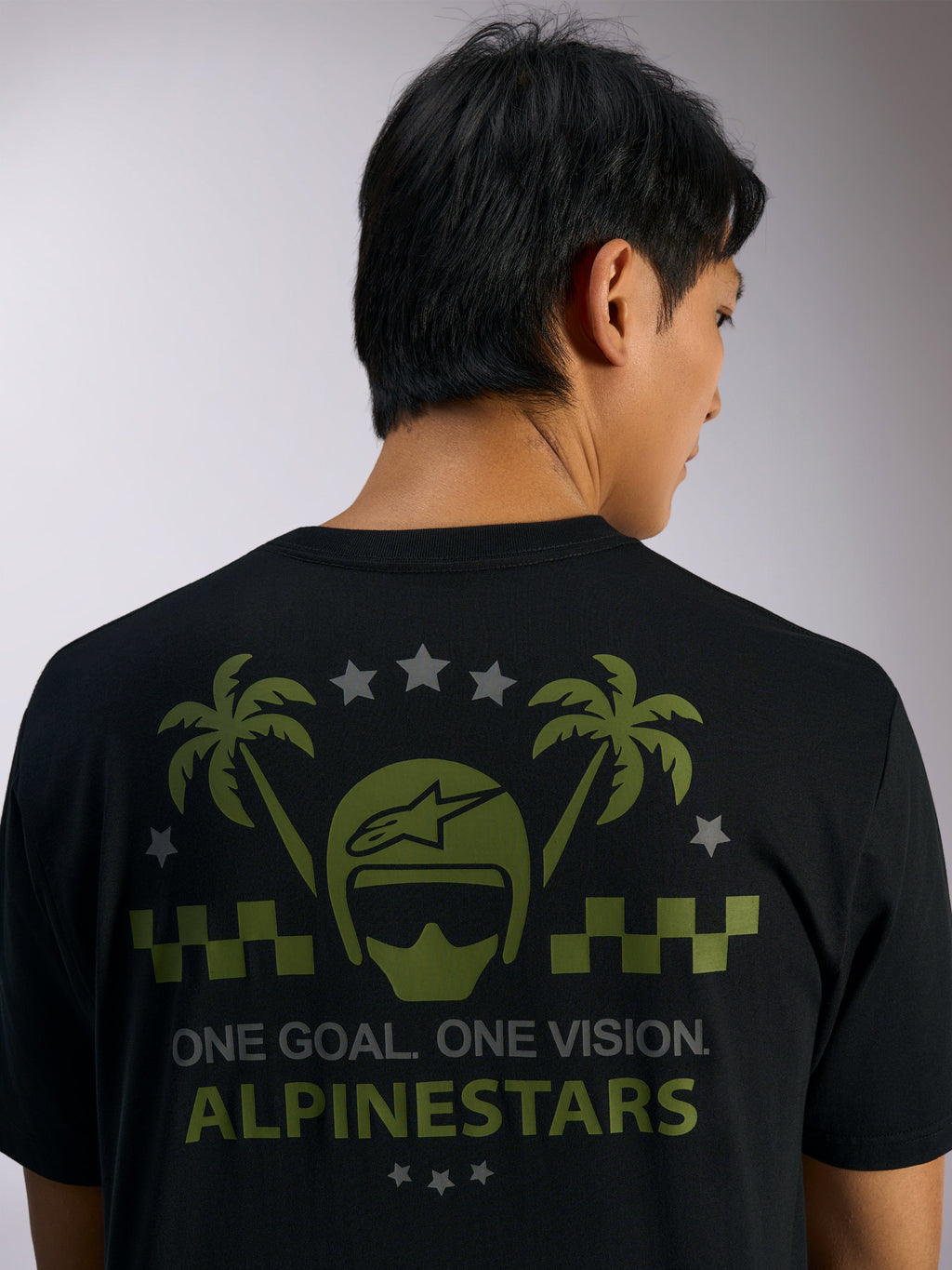 Alpinestars Order CSF Tee, t-shirt à manches courtes, noir, vue de dos présentant des graphismes de casque et de palmiers verts avec des étoiles grises et le texte « ONE GOAL. ONE VISION. ALPINESTARS », streetwear motorsport décontracté