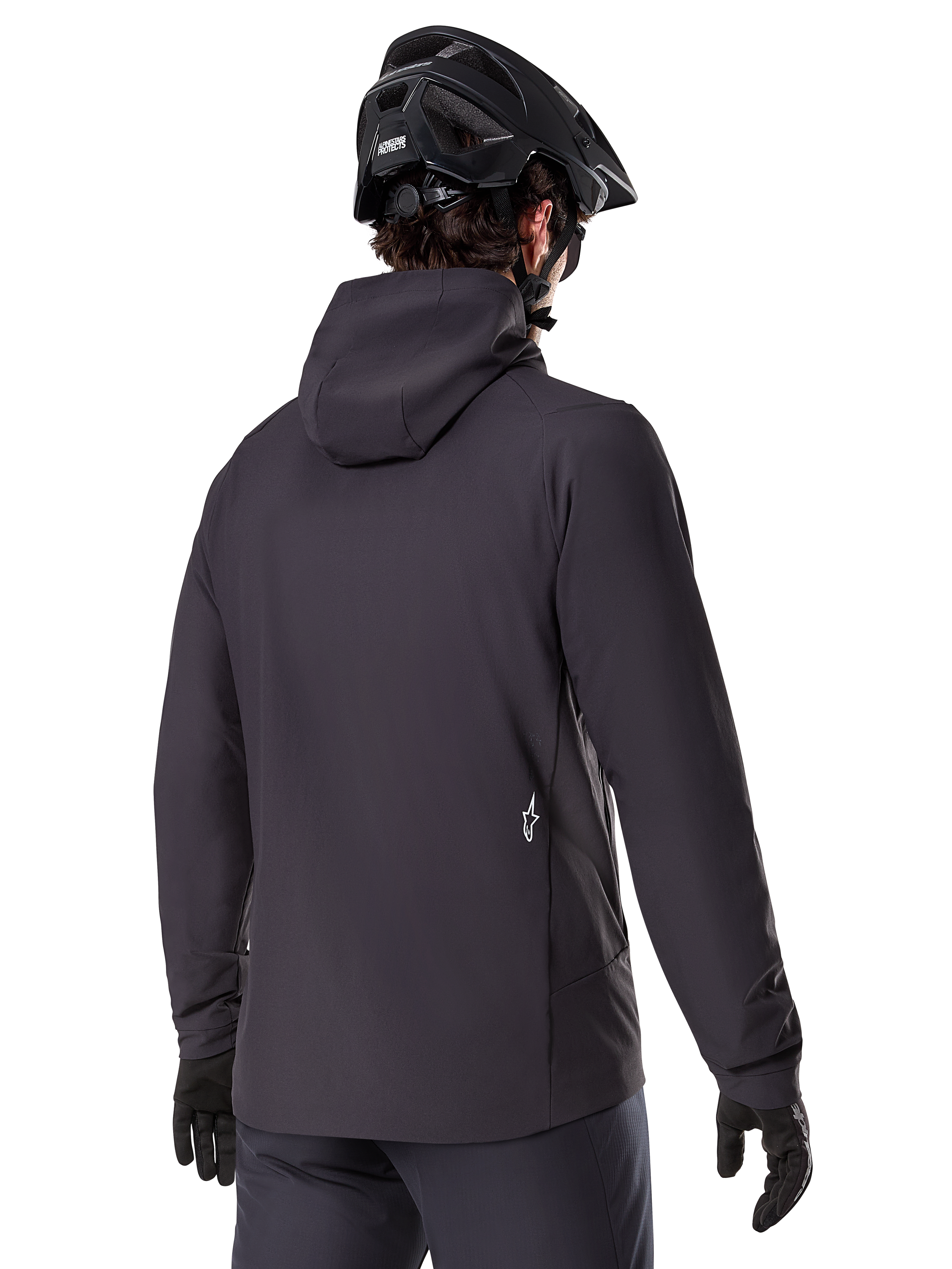 Veste thermique Alpinestars A-Dura, noire, vue de dos, portée avec un casque de VTT noir et des gants, avec un petit logo Astars blanc dans le bas du dos, veste de cyclisme légère et isolante