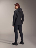 Alpinestars Stella A-Dura Thermal Jacket, MTB-fietsjack voor dames, zwart, achteraanzicht met focus op de geïsoleerde capuchon en normale pasvorm, gedragen met bijpassende zwarte broek en schoenen, lichtgewicht thermische isolatie voor ritten in koud weer