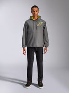 Alpinestars Speeder Chromium Windbreak Jas, houtskoolgrijze jas met capuchon met felgele voering en logo op de borst, volledige rits aan de voorkant, elastische manchetten, casual streetwear geïnspireerd op de motorsport