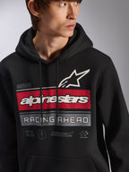 Alpinestars Harken Hoodie, zwarte pullover fleece hoodie gedragen door een model, met een grote graphic op de borst met rode en grijze strepen, wit Alpinestars woordmerk en sterlogo, 'Racing Ahead' tekst, moderne op motorsport geïnspireerde casual streetwear.