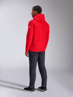 Sweat à capuche Frontal Alpinestars, sweat à capuche en polaire rouge, vue de dos montrant le logo wordmark blanc sur la manche, porté avec un pantalon en jean foncé et des chaussures noires, style streetwear décontracté motorsport