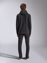 Alpinestars Frontal Hoodie, lässige Streetwear, Schwarz, Rückansicht eines Models im Fleece-Kapuzenpullover, mit Rippbündchen an Saum und Ärmeln, kleines weißes Wortmarken-Logo am Ärmel, kombiniert mit schwarzer Hose