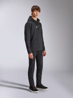Alpinestars Frontal Hoodie, Noir, sweat à capuche en polaire avec logo HD blanc sur la poitrine et logos sur les manches, poche kangourou, porté avec un pantalon noir et des baskets, style streetwear décontracté inspiré du sport automobile