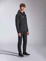 Alpinestars Frontal Hoodie, Schwarz, Fleece-Kapuzenpullover mit weißem HD-Logo auf der Brust und Wortmarken-Logos auf den Ärmeln, Kängurutasche, kombiniert mit schwarzer Hose und Sneakern, lässige vom Motorsport inspirierte Streetwear