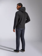 Alpinestars Blaze V3 Hoodie, back view of a man wearing the black pullover hoodie, paired with dark jeans and black sneakers, casual motorsport-inspired streetwear