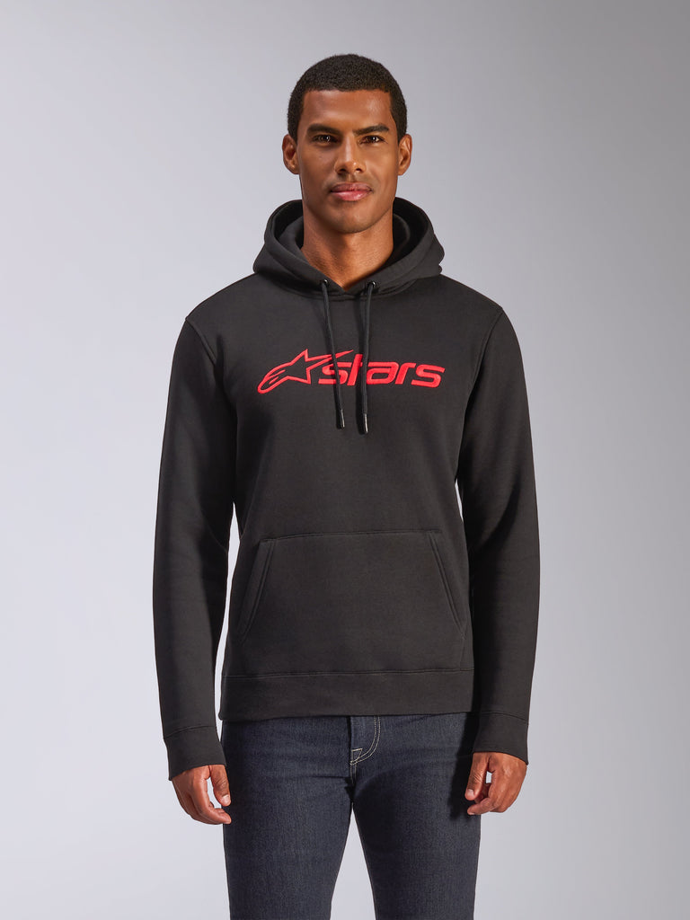 Sweat à capuche Alpinestars Blaze V3, sweat en polaire pour homme, noir avec logo Alpinestars rouge, porté par un homme avec un jean foncé, doté d'une capuche à cordon de serrage et d'une poche kangourou, streetwear décontracté inspiré des sports mécaniques