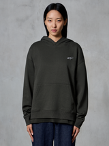 Alpinestars Essentials Ageless Hoodie, Off Black, gedragen door een model, met een klein wit Astars-logo op de borst, kangoeroezak aan de voorkant, stone-wash afwerking, casual premium fleece streetwear