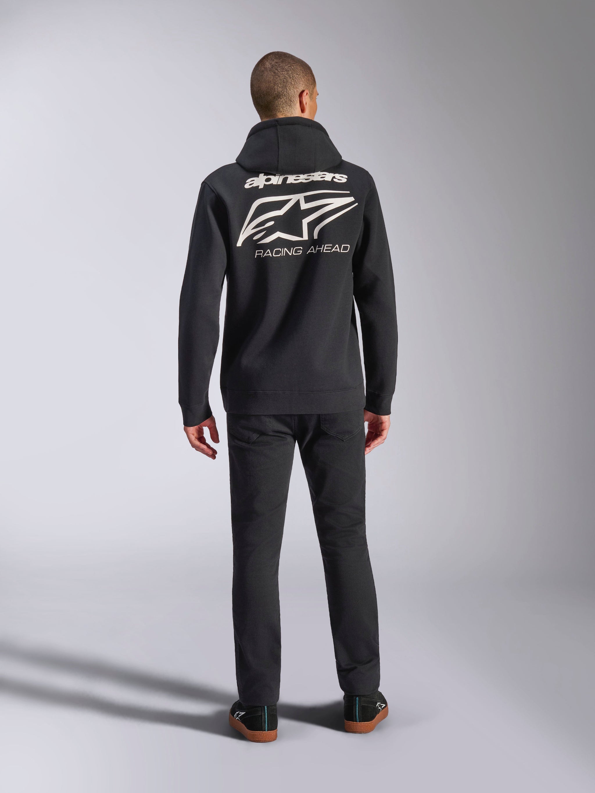 Alpinestars Formulation Hoodie, Schwarz, Rückansicht am Modell mit großem weißem Alpinestars-Logo und 'Racing Ahead'-Schriftzug, lässige Motorsport-inspirierte Streetwear