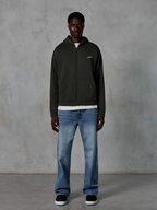 Alpinestars Essentials Ageless Zip Hoodie, hoodie met volledige rits, Off Black, voorzien van een klein wit Alpinestars-logo op de borst, gedragen door een model met een wit t-shirt en blauwe jeans, ontspannen pasvorm, casual motorsport streetwear