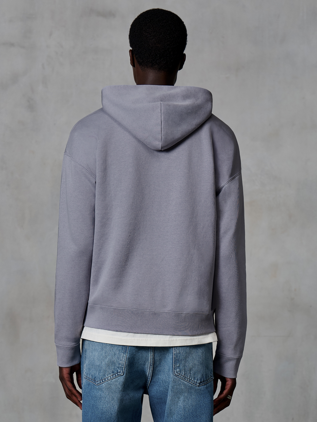 Alpinestars Essentials Ageless Zip Hoodie, zilver, achteraanzicht, casual streetwear, ontspannen pasvorm met garment stone wash-afwerking, gecombineerd met blauwe jeans en wit ondershirt
