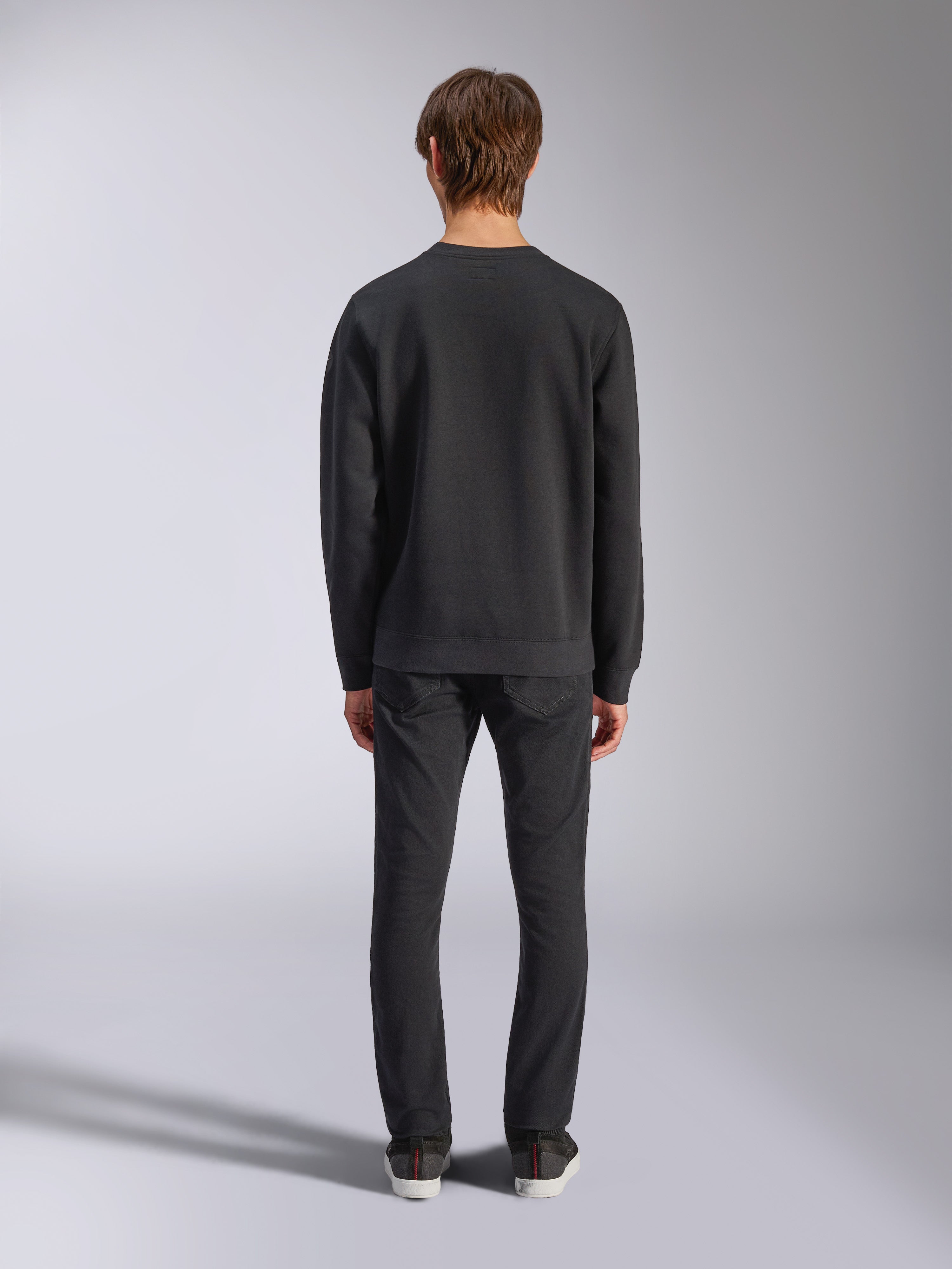Alpinestars Bettern Crew, sweat à col rond noir, vue de dos sur modèle, col et ourlet côtelés, streetwear décontracté inspiré du sport automobile