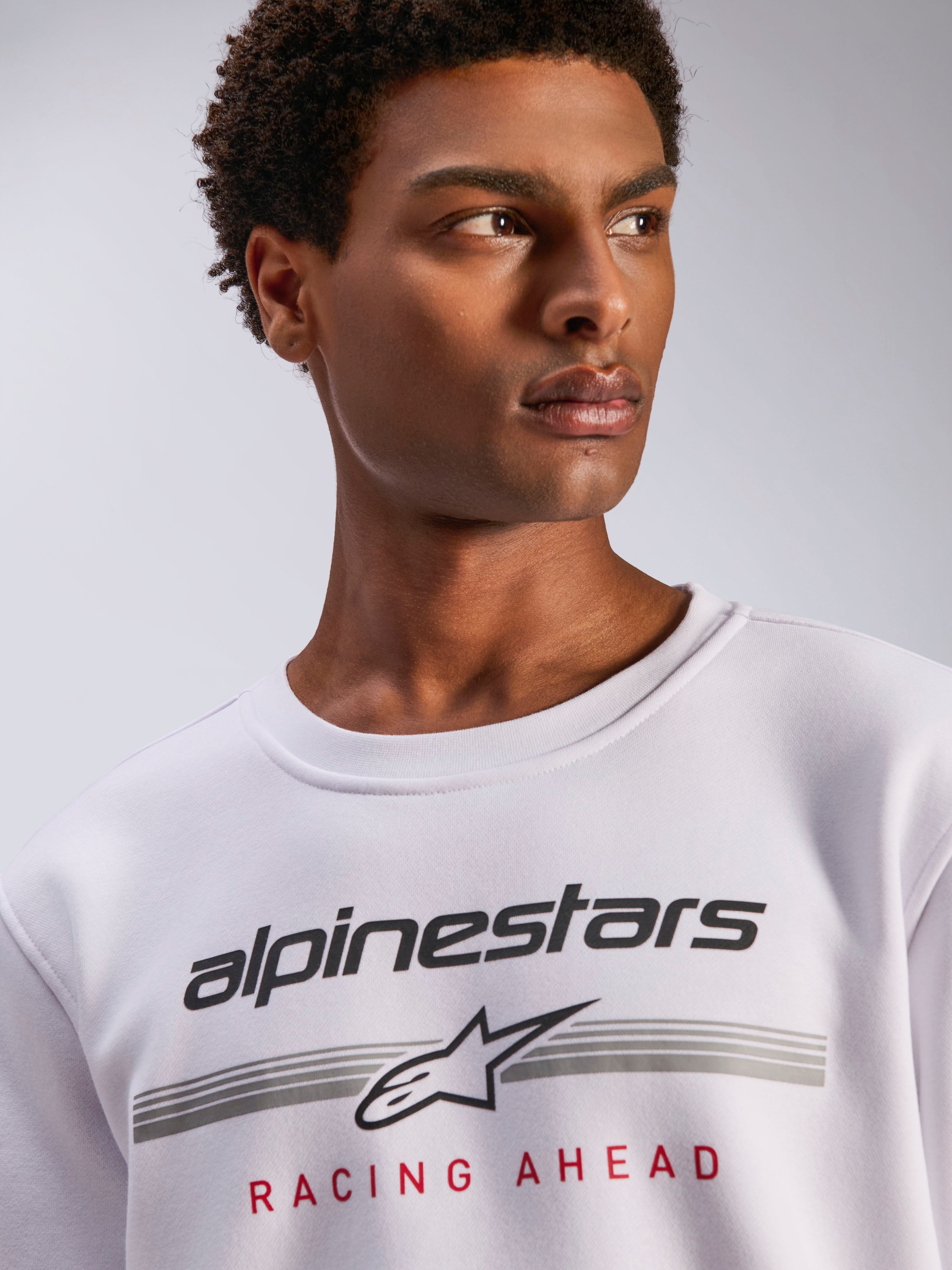 Alpinestars Bettern Crew, sweat à col rond en polaire blanche, logo Alpinestars noir avec lignes horizontales grises et texte 'Racing Ahead' rouge, vêtement streetwear décontracté inspiré du sport automobile