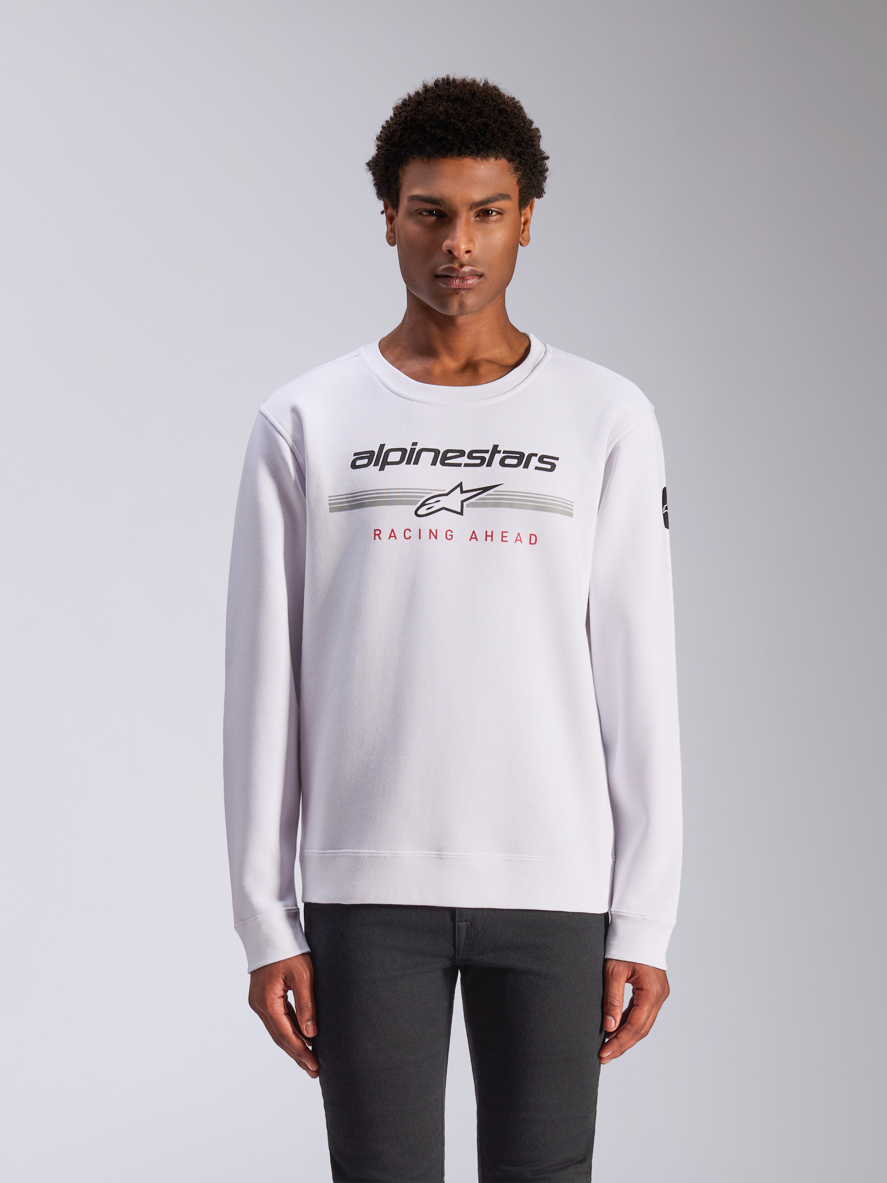 Alpinestars Bettern Crew, sweat à col rond, blanc, avec logo Alpinestars noir, rayures horizontales grises et texte rouge « RACING AHEAD », streetwear de sport automobile décontracté