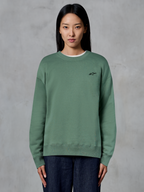 Alpinestars Essentials Ageless Crew, crewneck sweatshirt, cactus groen, gedragen door een model, klein zwart logo op de borst, geribbelde kraag, manchetten en zoom, casual motorsport streetwear