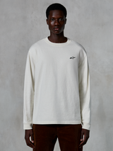 T-shirt à manches longues Alpinestars Essentials Ageless, blanc cassé, petit logo étoile noir sur la poitrine, streetwear décontracté, coupe décontractée, porté par un mannequin