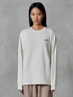 T-shirt à manches longues Alpinestars Essentials Ageless, blanc cassé, avec un petit logo étoile noir sur la poitrine, coupe contemporaine décontractée, jersey de coton biologique, streetwear décontracté inspiré du sport automobile