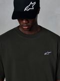 Alpinestars Essentials Ageless SS Tee, T-shirt met korte mouwen, Off Black, met een klein wit Alpinestars-logo op de borst, gedragen met een zwarte baseballcap met logo, casual motorsport streetwear stijl