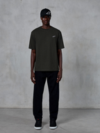 Alpinestars Essentials Ageless SS Tee, T-shirt met korte mouwen, Off Black, met een klein wit Alpinestars-logo op de borst, gedragen door een model met een zwarte pet en broek voor een strakke lifestyle-look