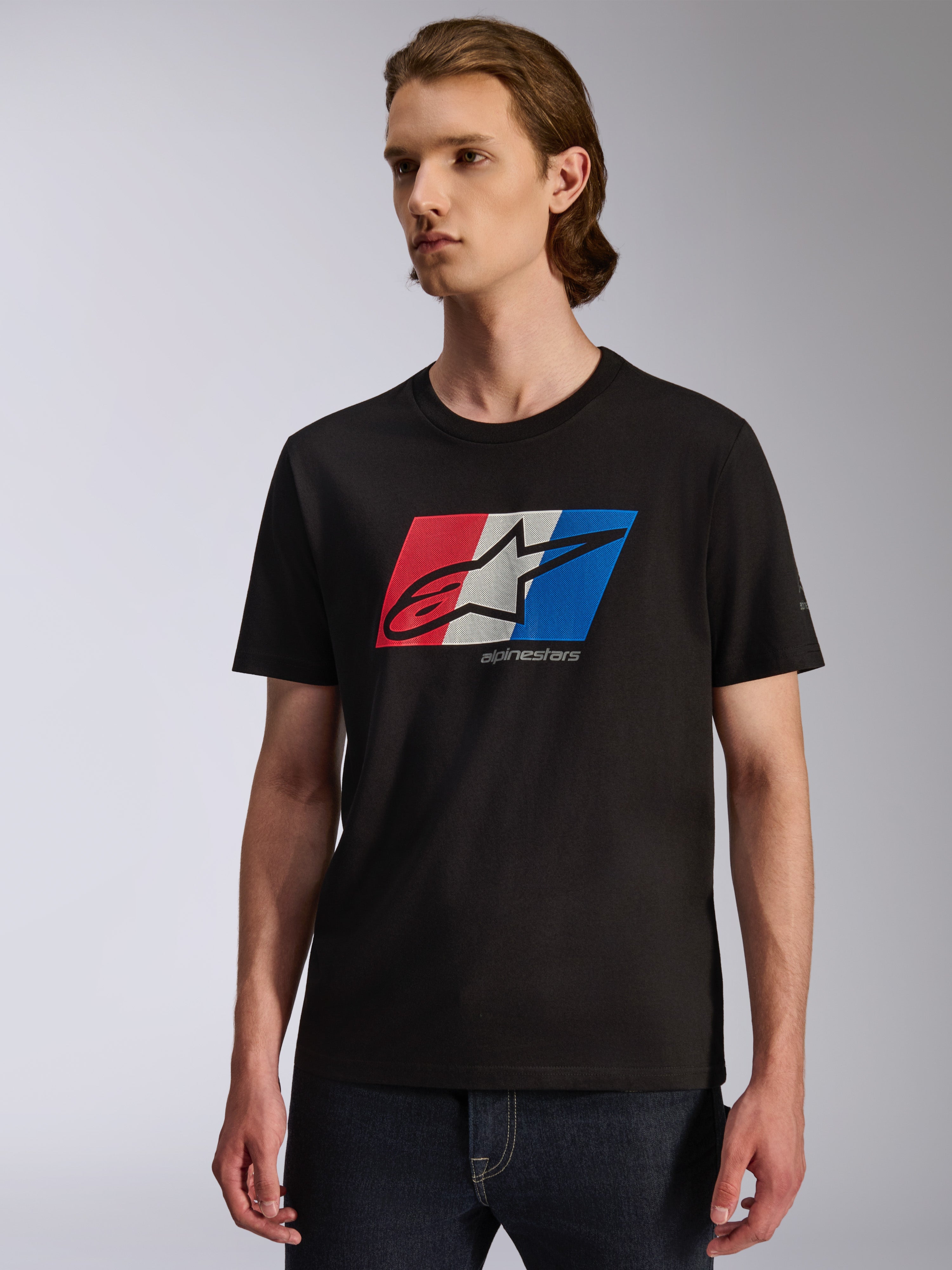 Alpinestars Global CSF Tee, T-shirt met korte mouwen, zwart met rood, wit en blauwe grafische print op de borst, Ageless shadow-logo, casual op de motorsport geïnspireerde streetwear, model draagt het T-shirt