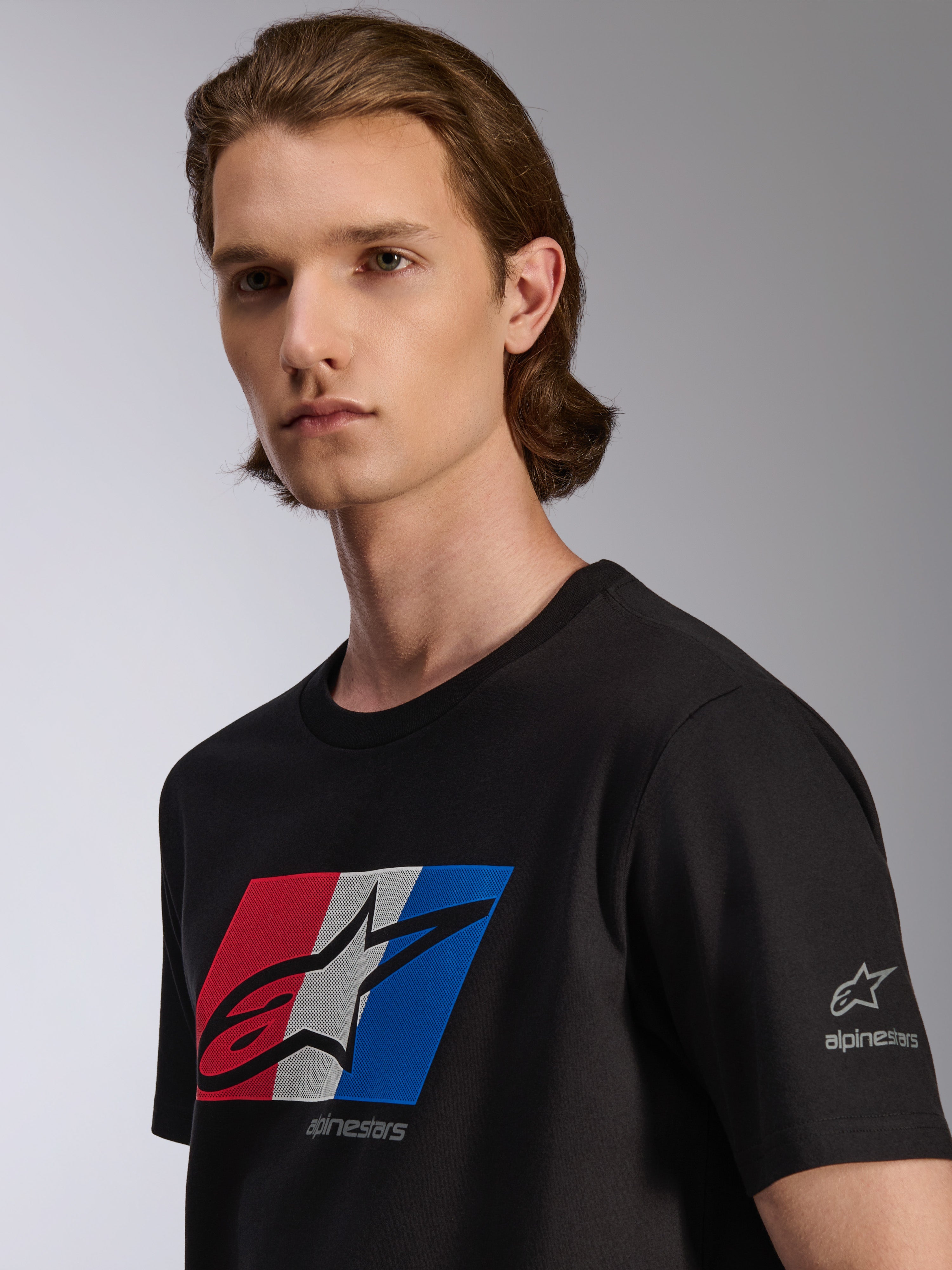 Alpinestars Global CSF Tee, T-shirt met korte mouwen, zwart, rood, wit en blauwe graphic met zwart shadow-logo, detailweergave op model, casual motorsport streetwear