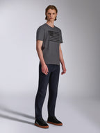 Alpinestars Waving CSF Tee, T-shirt met korte mouwen, antraciet, zwarte grafische print van een wapperende vlag, gedragen door een model met donkere jeans en sneakers, casual motorsport streetwear