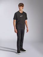 Alpinestars Frontal CSF Tee, T-shirt met korte mouwen, zwart, wit Astars-logo op de borst, gedragen door een model met donkere jeans en zwarte sneakers, casual performance streetwear