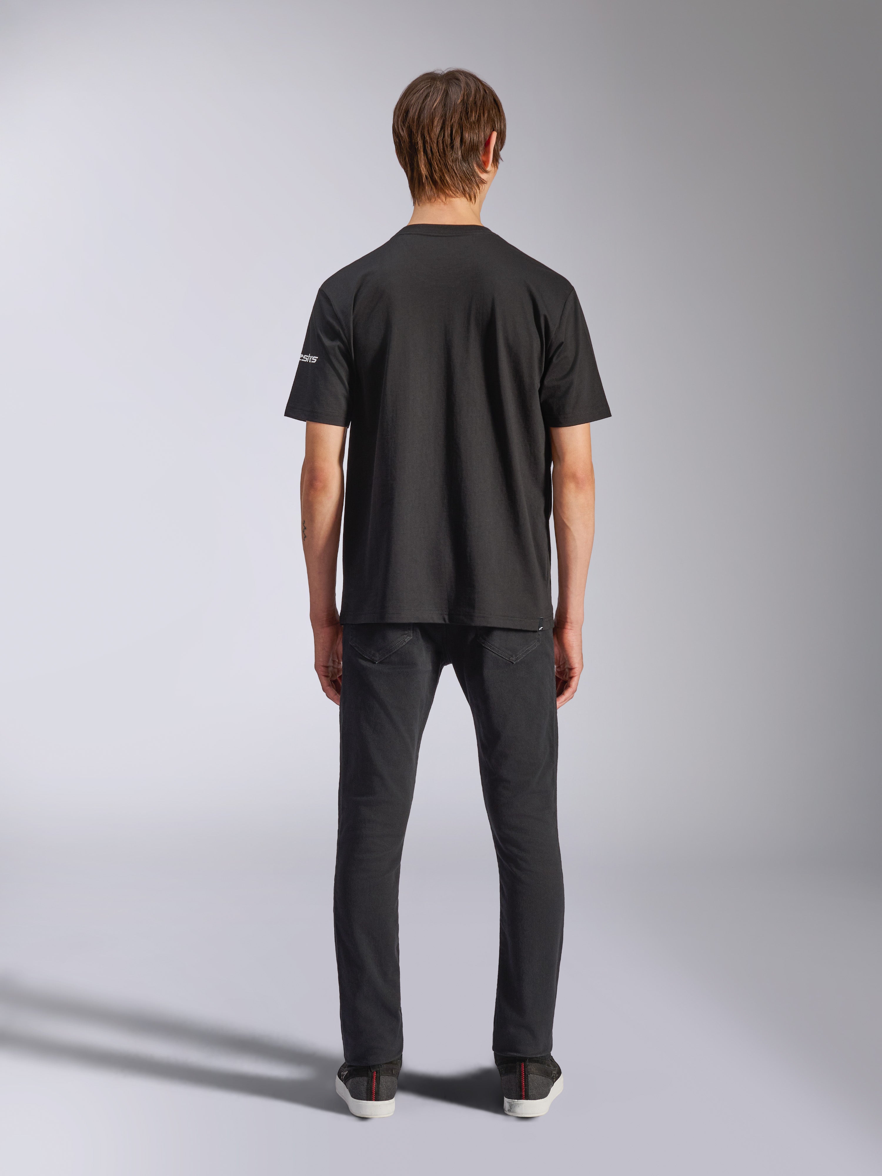 Alpinestars Frontal CSF Tee, T-shirt met korte mouwen, zwart, achteraanzicht op model in een zwarte jeans, casual performance streetwear met een klein wit logodetail op de mouw