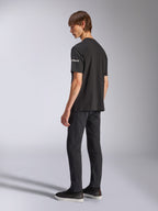Alpinestars Frontal CSF Tee, T-shirt met korte mouwen, zwart, witte Astars-branding op de mouw, gedragen door model met zwarte broek en schoenen, casual motorsport-geïnspireerd ontwerp