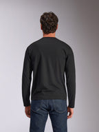 Alpinestars Trackside CSF Tee, T-shirt met lange mouwen, zwart, achteraanzicht, gedragen met een donkerblauwe spijkerbroek, casual motorsport-geïnspireerde streetwear